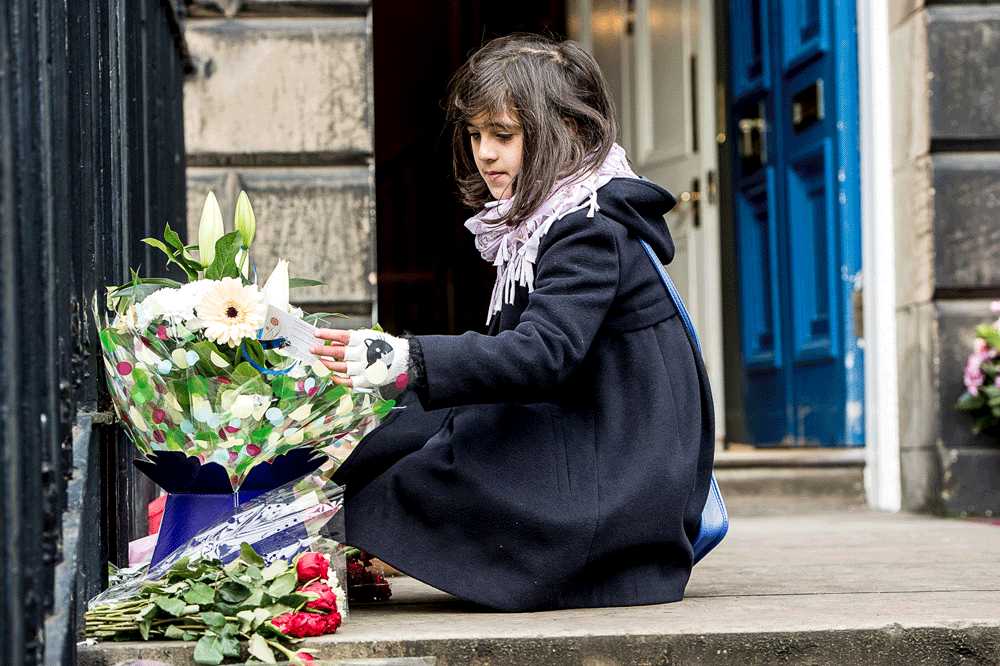 News: a young French girl reading cards on the flowers outside the French Consulate General's office in Edinburgh, the morning after the Bataclan (sp) shootings