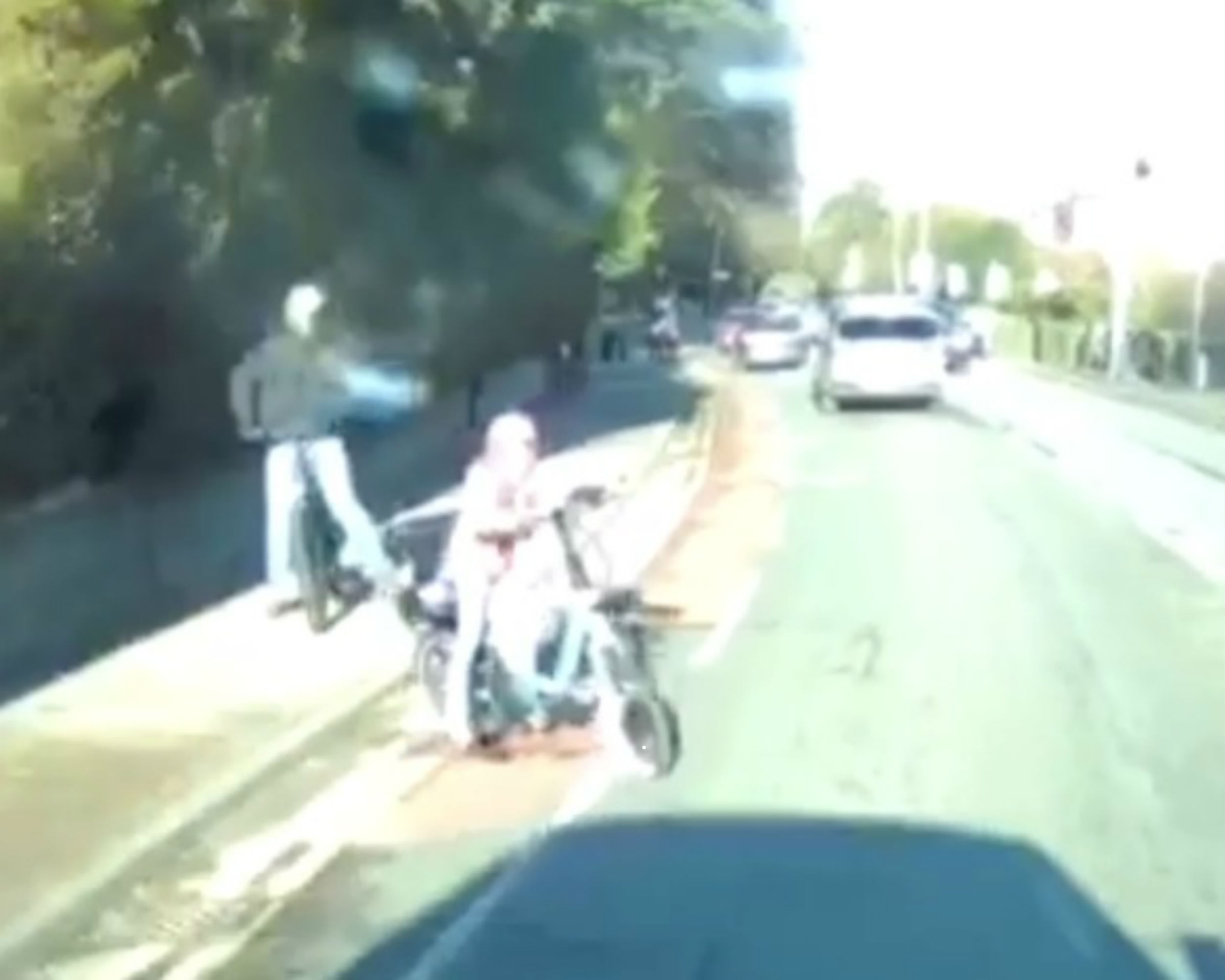 As her bike careers off the road, the driver makes a sudden stop and caught the near miss on his dashcam