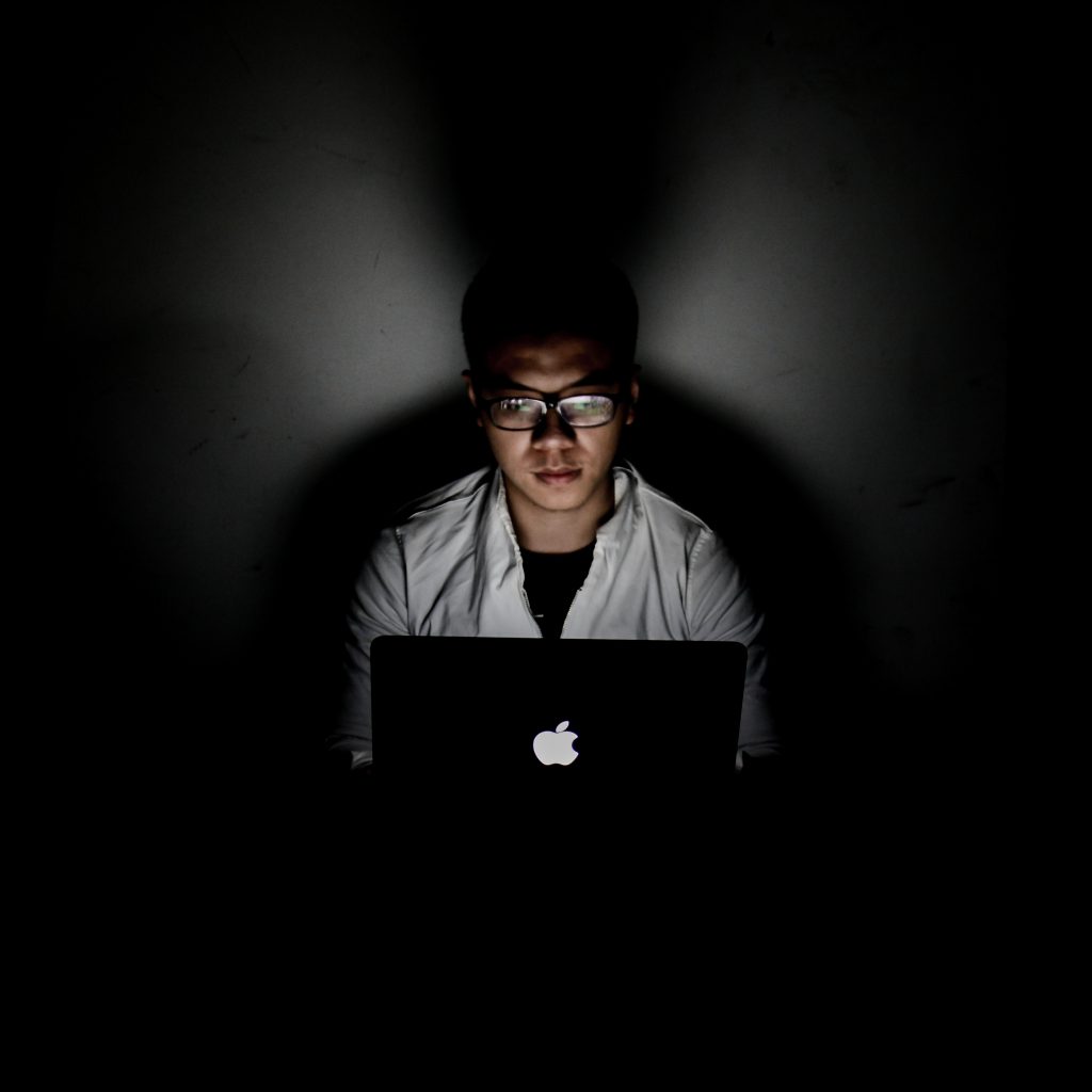 A guy in the dark on a computer