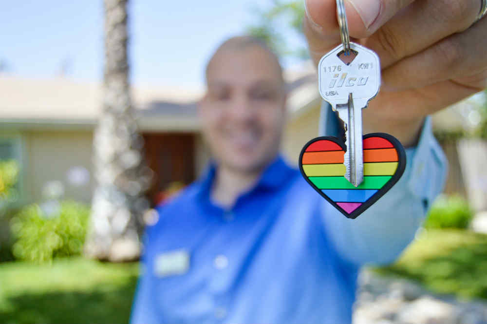 Real Estate agent holds up colourful keyring
