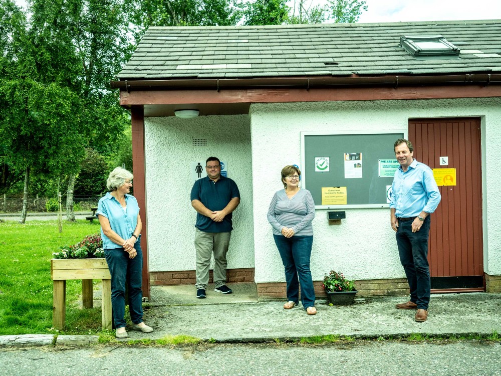 Members of the Shieldaig Community Association gather outside for a photo in front of the public toilets