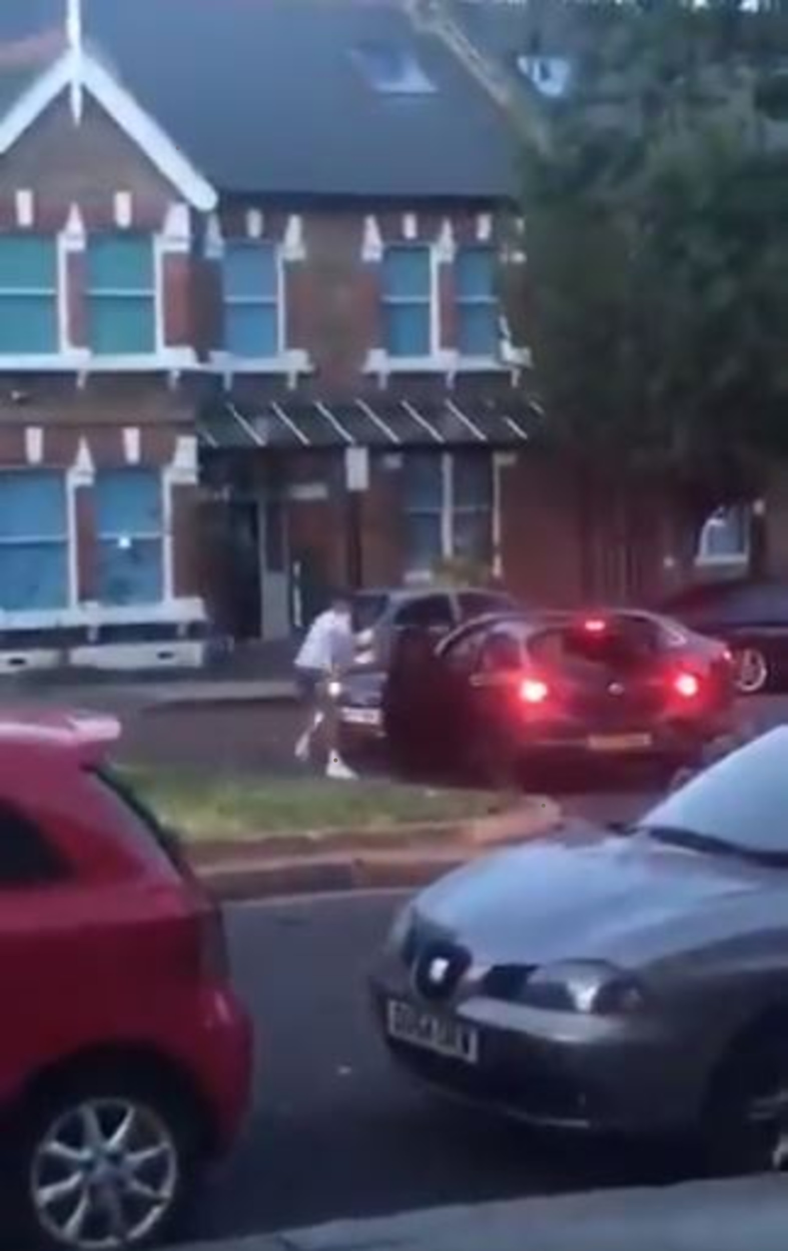 One of the men approaches the car and strikes it with an object in his hand.- Viral Video News