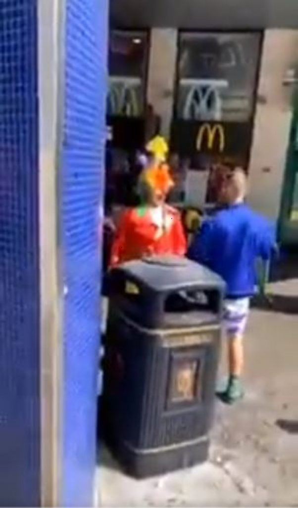 BIZARRE footage shows an altercation between a clown and an umbrella-wielding attacker outside a McDonalds.