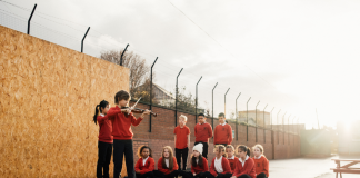 A group of children playing music on an outdoor stage - Entertainment News Scotland