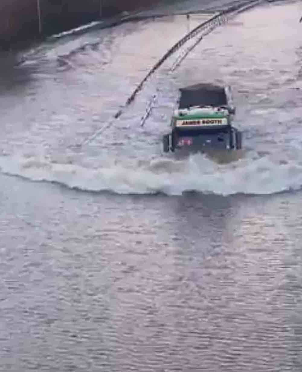 VIDEO shows a determined lorry driver ploughing through a heavily flooded carriageway - Video News UK