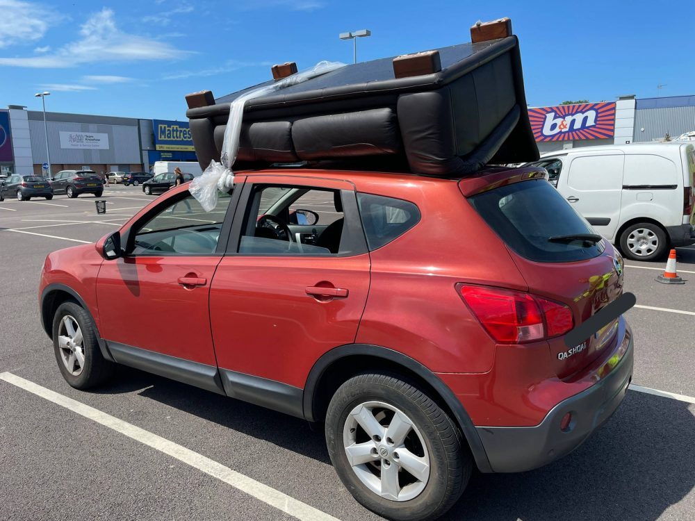 The red Nissan with a sofa tied to the roof | Traffic News UK