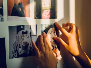 Girl putting anime pictures on a wall - Scottish News