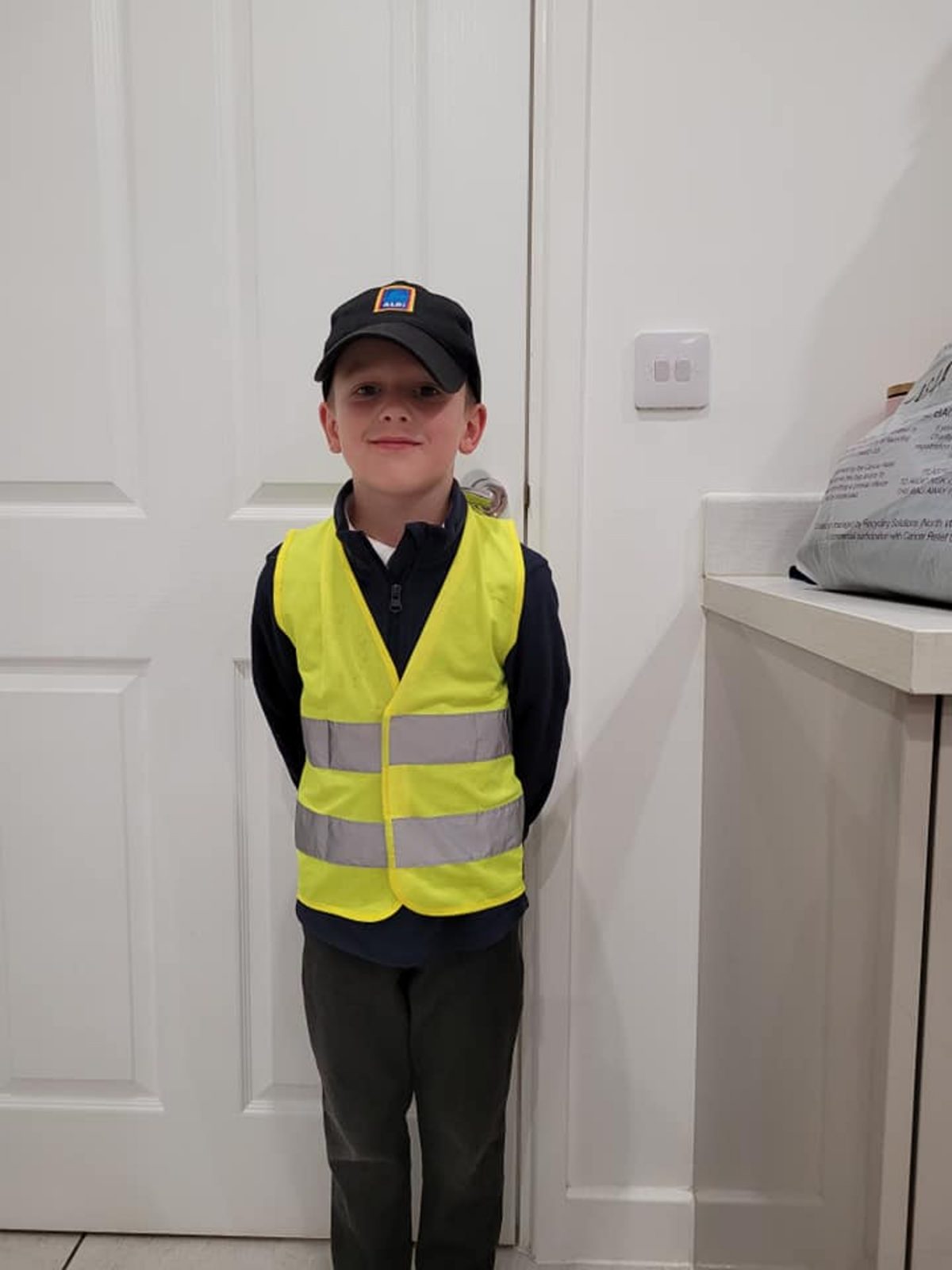 Oliver posed for the camera, dressed as his Aldi HGV driver dad James.