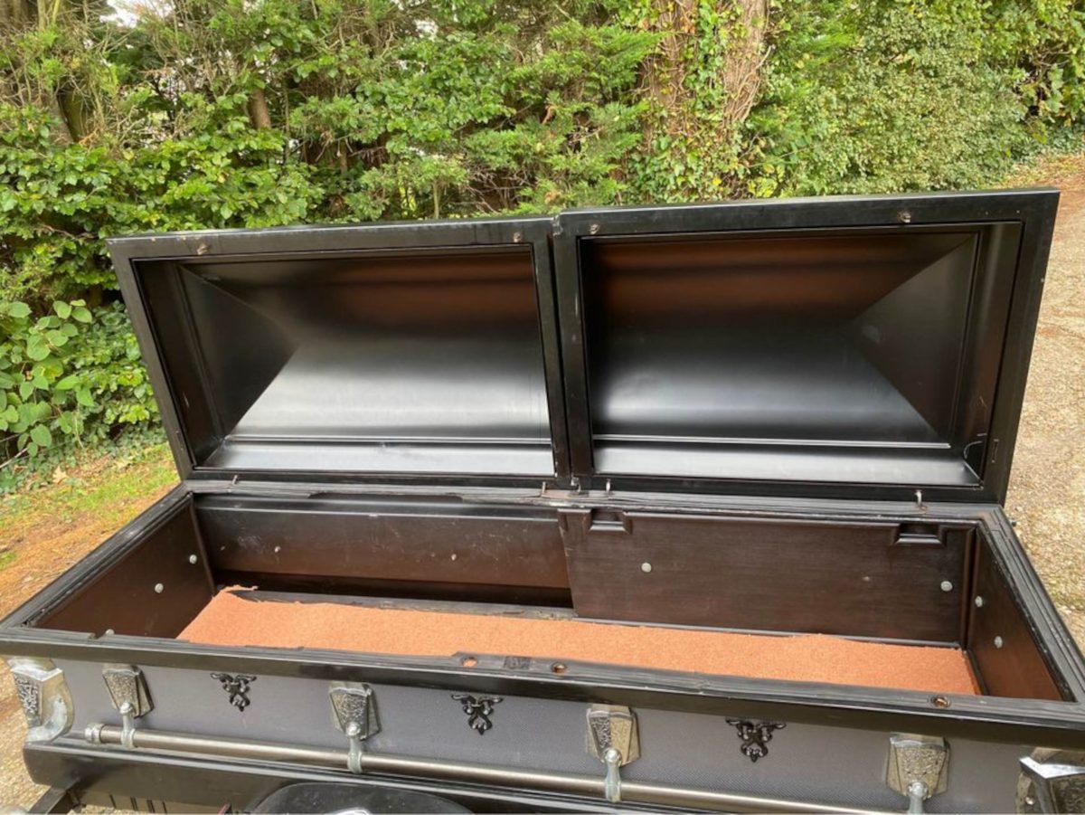 The casket pictured open, showing the wooden interior