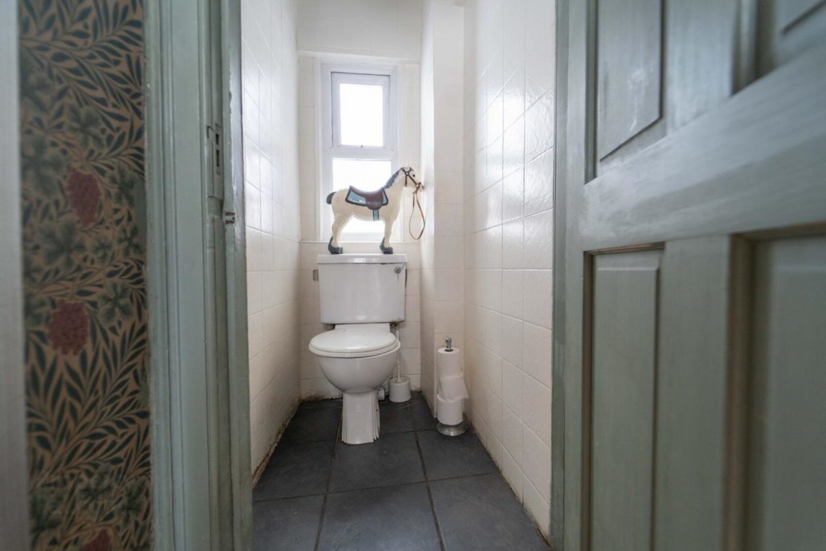 WC with an ornamental horse on top of the cistern