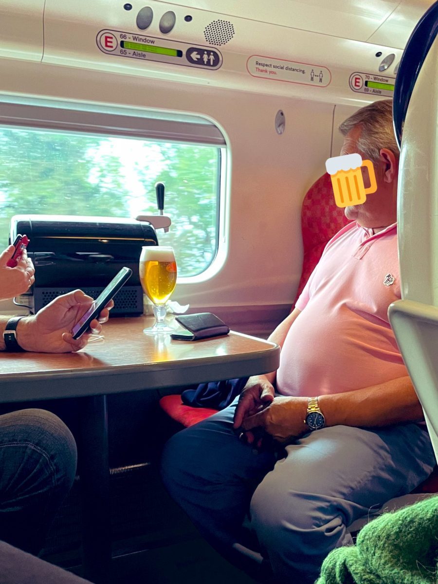 Man with a pint on train