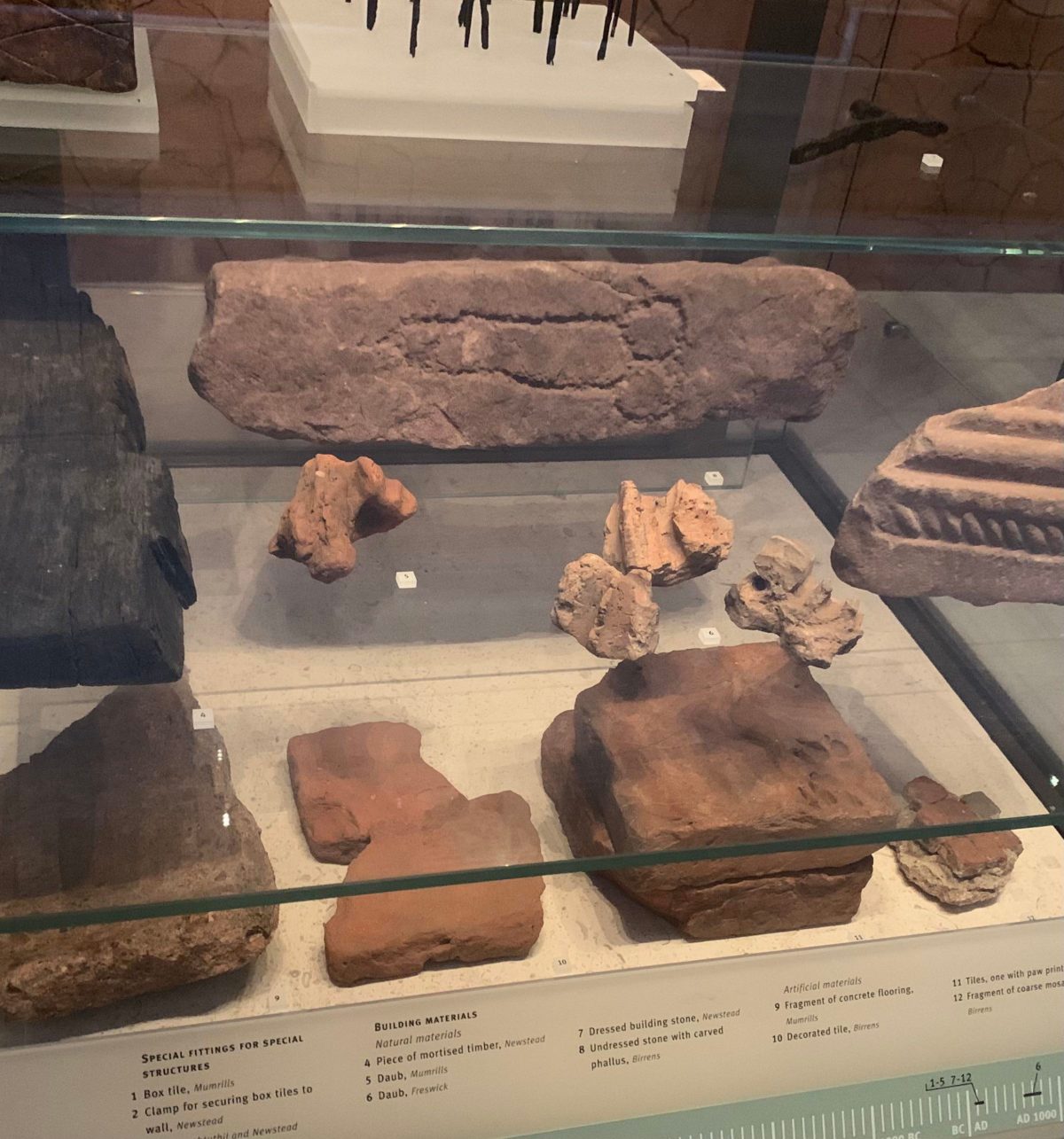 The brick with the carved penis in it, on exhibit at the National Museum of Scotland.