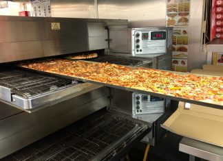 The gigantic pizza going into the oven