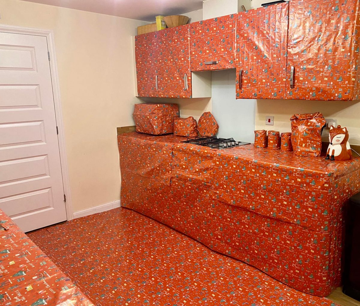 The kitchen wrapped in Christmas paper as part of the Elf on the Shelf plan.