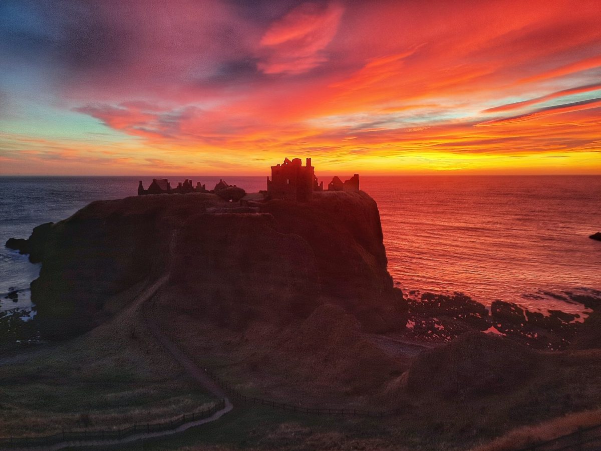 Dunnottar Castle with shades of purple and orange across the skyline.