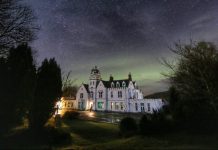 Photo of Skeabost House Hotel, with Northern Lights behind it.