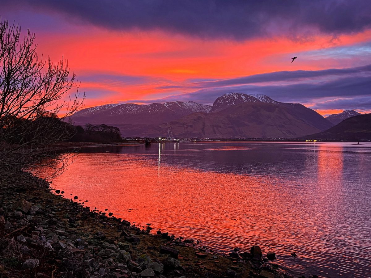 Image of Ben Nevis from the shores of Loch Eil, with purple and orange on the skyline.