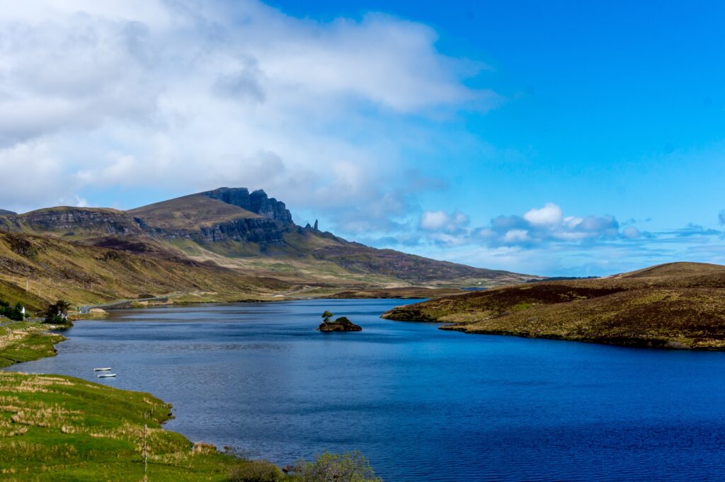 Scottish island landscape, with body of water, island, mountain and sky.
