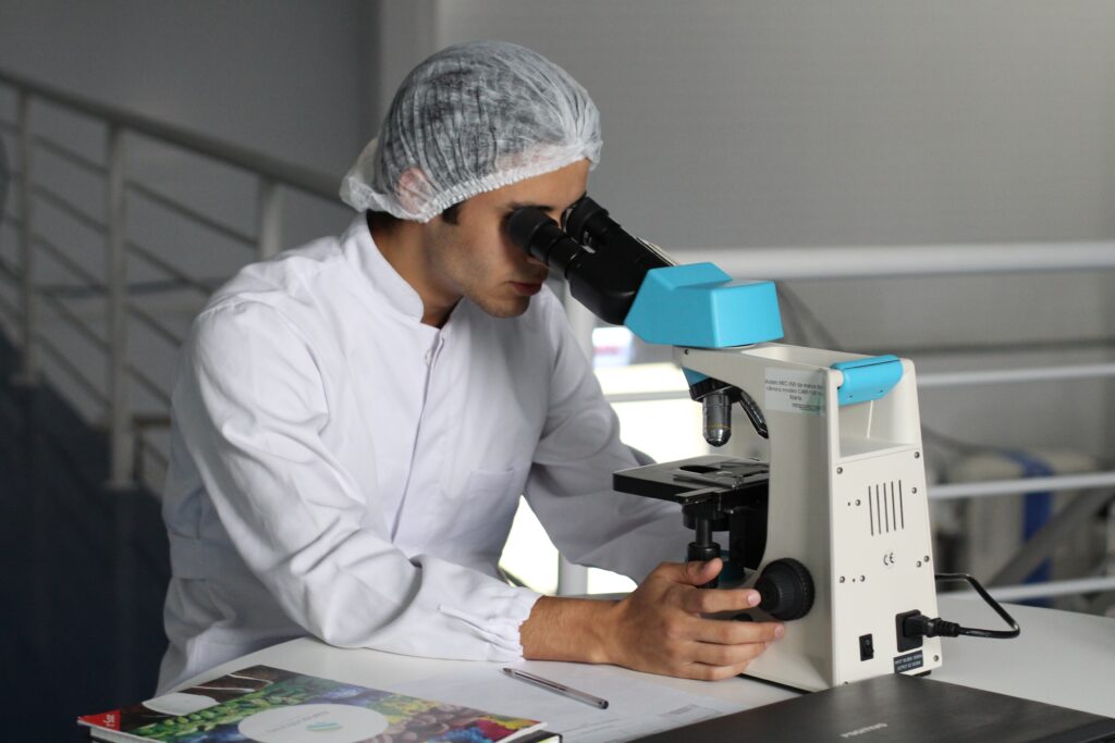 Medical researcher looking through microscope.
