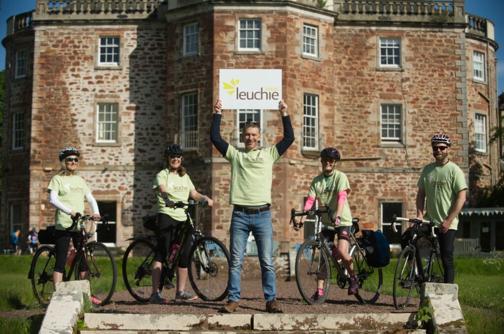 Leuchie CEO, Mark Bevan, alongside several riders, promoting Leuchie House.