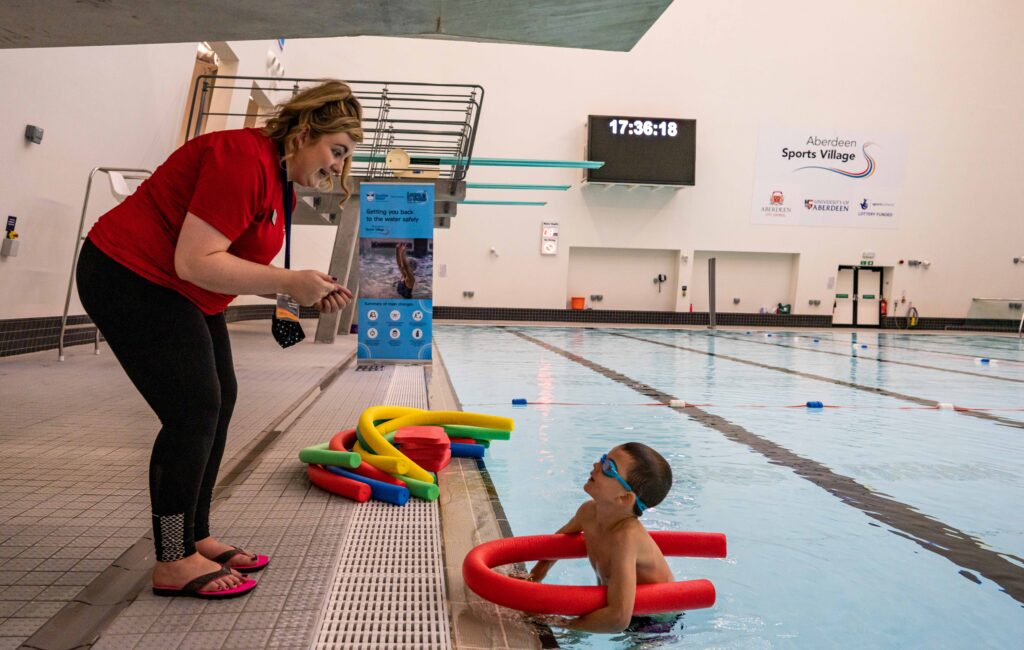 Instructor speaking to a learner in the pool. 