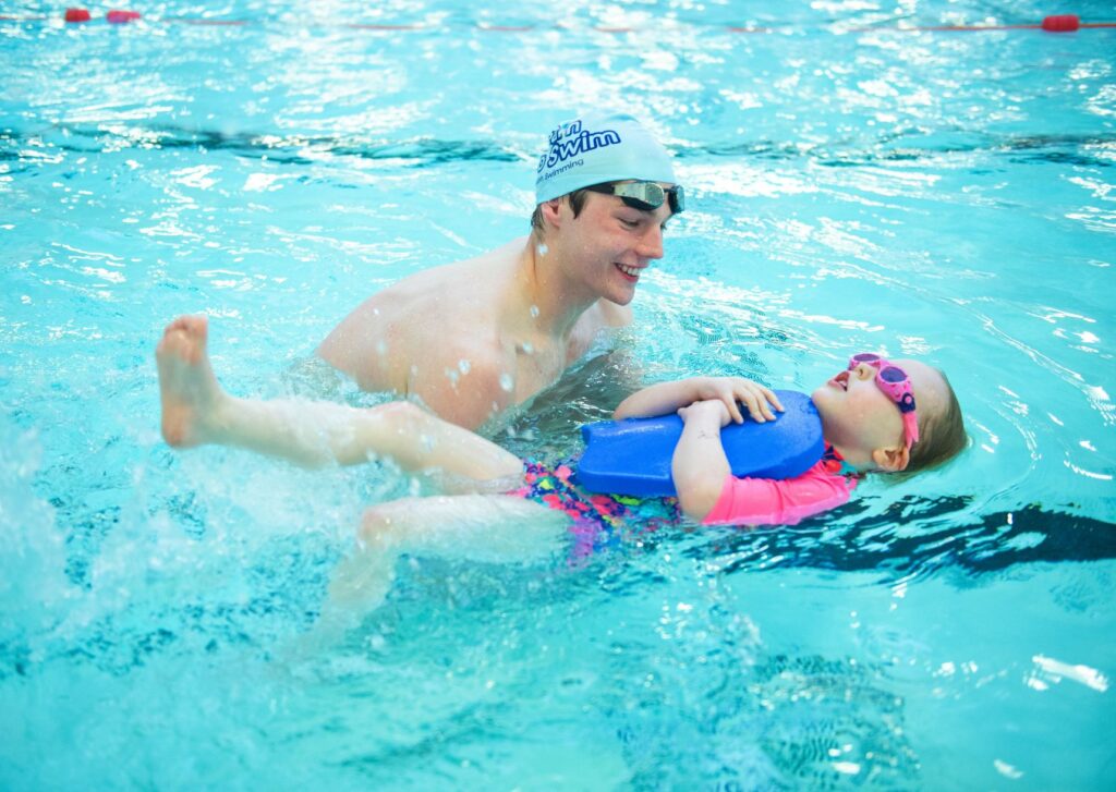 Olympic athlete Duncan Scott with child in pool.