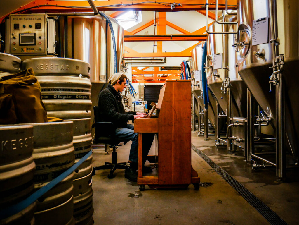 Sean Logan playing piano to a batch of beers at Bellfield's brew house.