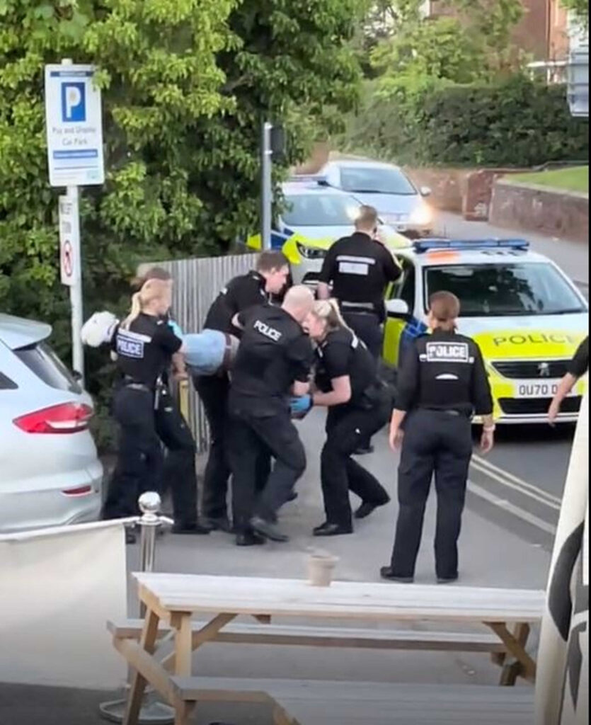 Police carry the second man out of the pub