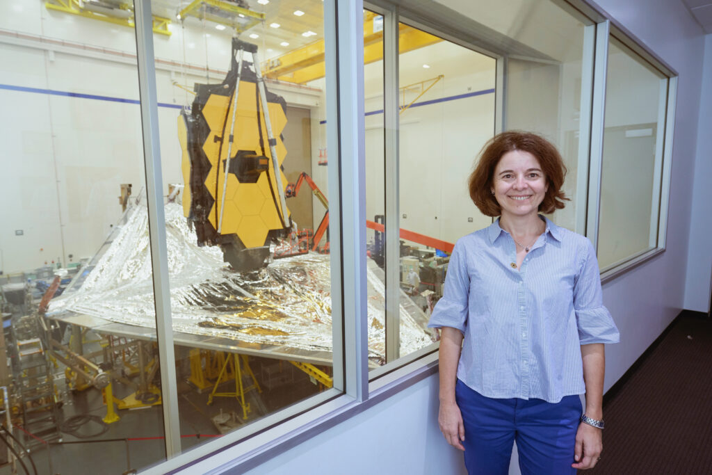 Data scientist Dr. Giovanna Giardino with the JWST in the background.