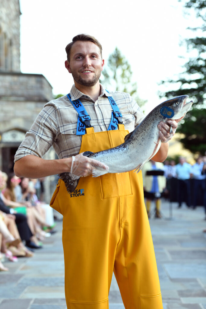 Loch Duart's model pictured on the runway in yellow oilskin trousers, whilst holding one of the Loch's salmon.