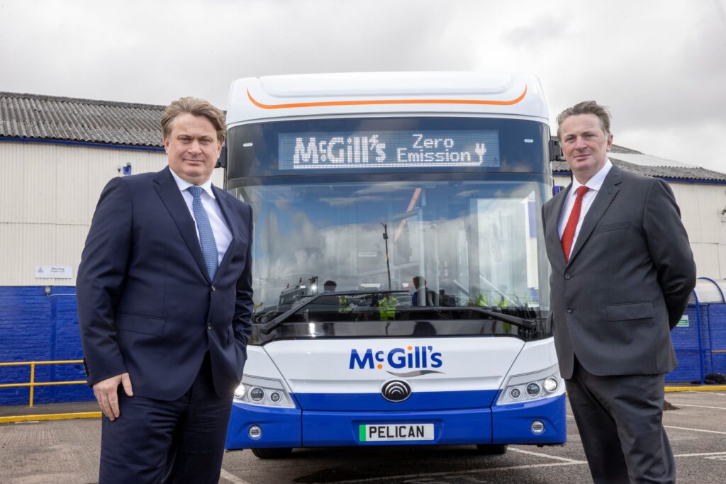 Sandy and James Easdale in front of a McGill's branded bus. 