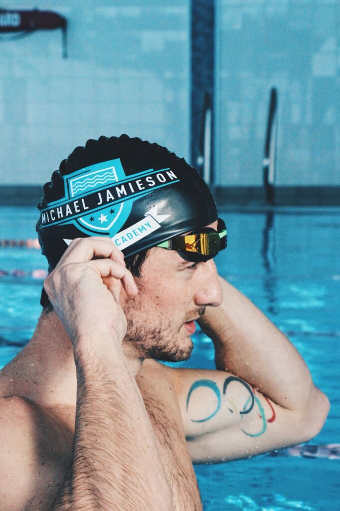 Michael Jamieson in the pool wearing a Swimming Academy swimming cap.