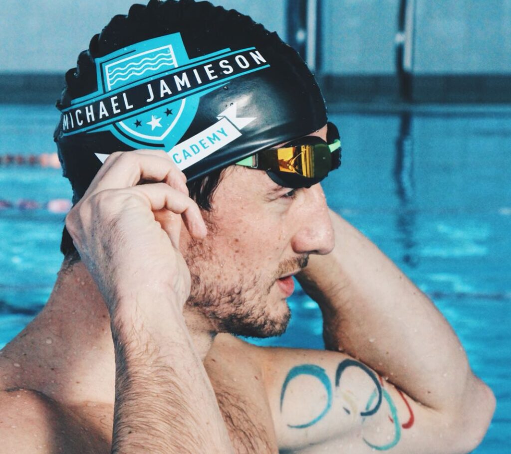 Michael Jamieson in a swimming pool with his Swimming Academy swim cap on.
