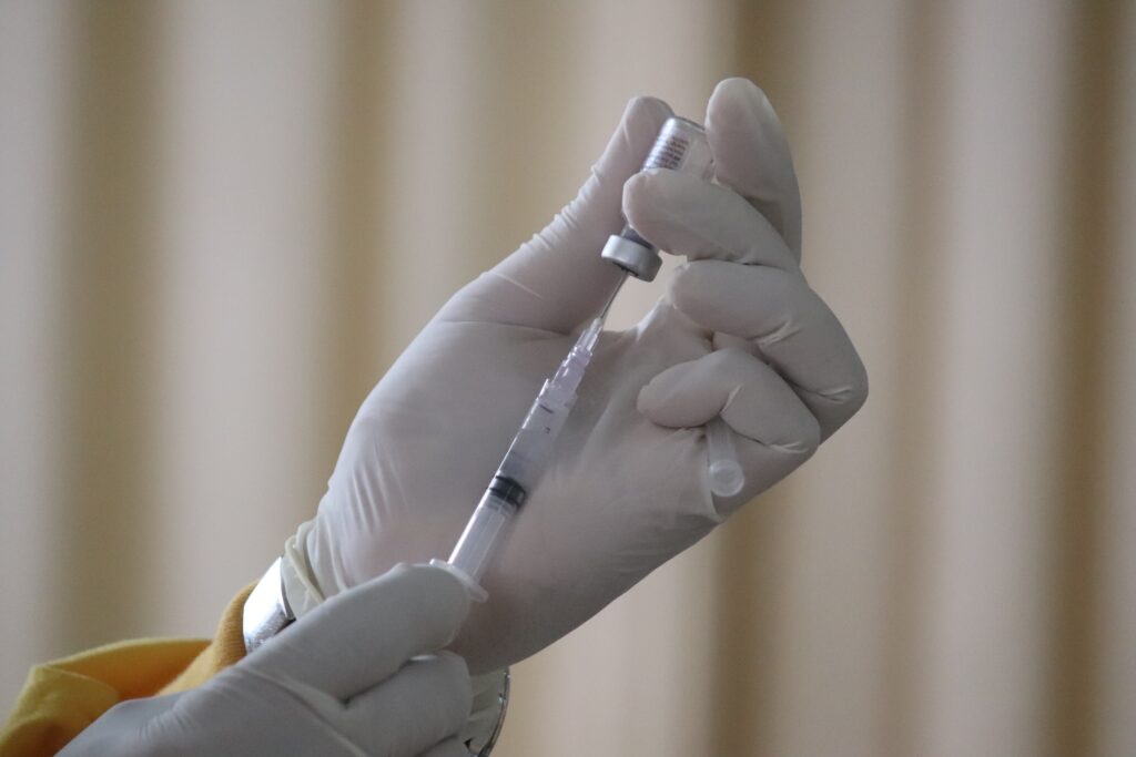 Nurse holding a syringe and vaccine bottle.