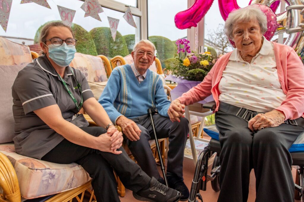 A Plus Homecare carer sitting alongside two clients as part of their in-home care service.