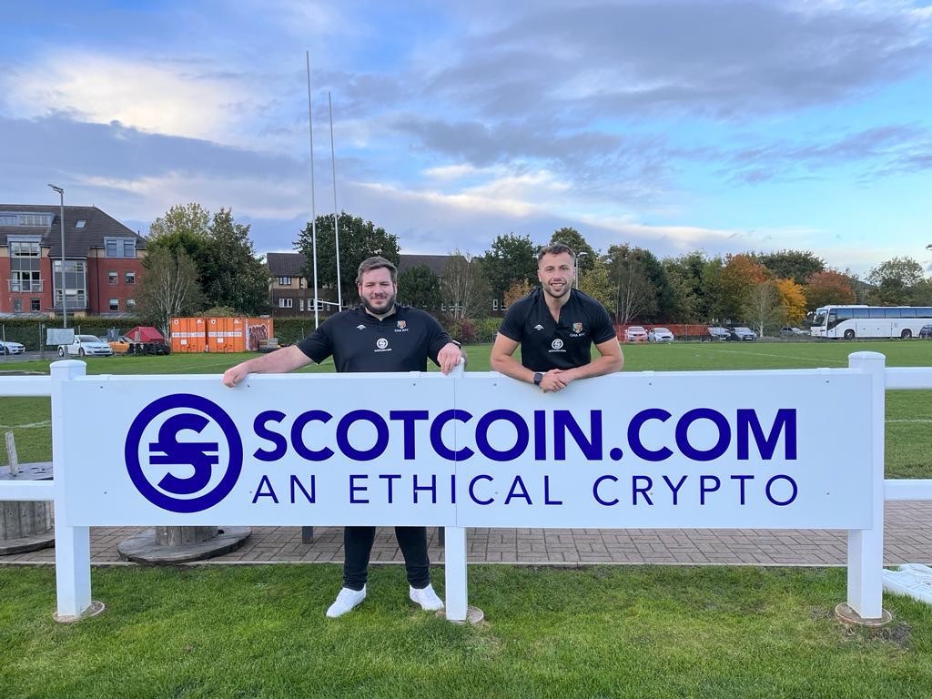 Scotcoin billboard with two GHA team members.