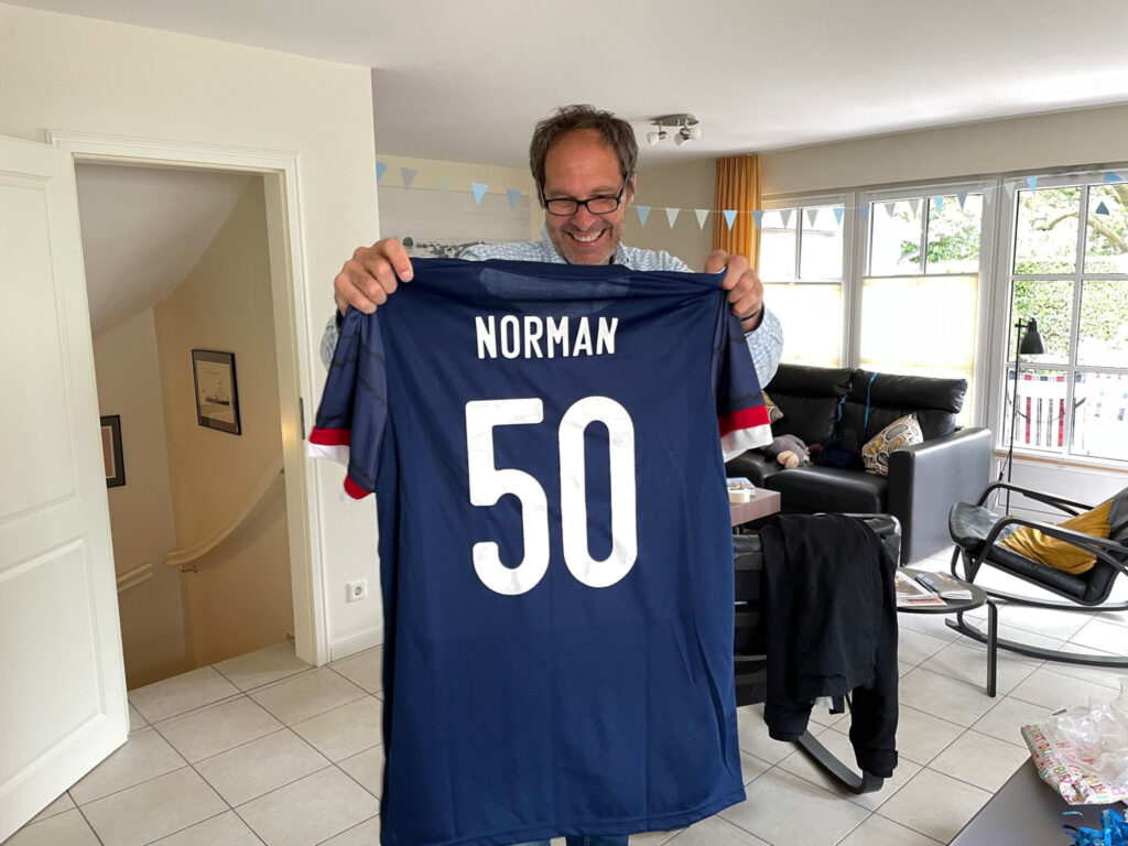 Norman Nawe holding a Scotland shirt