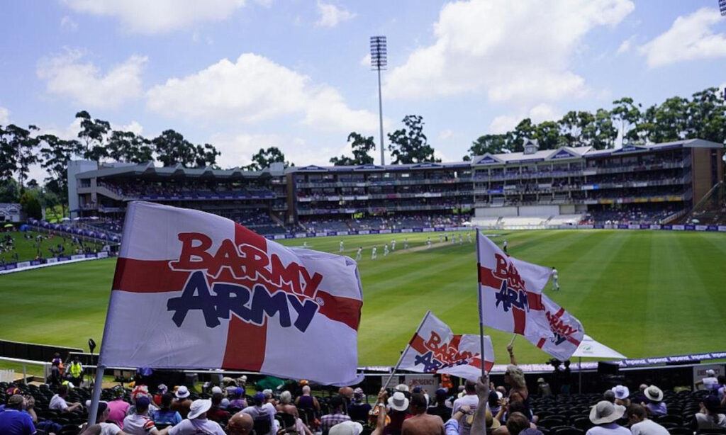 Barmy Army waving their flags in the stands of a cricket ground.