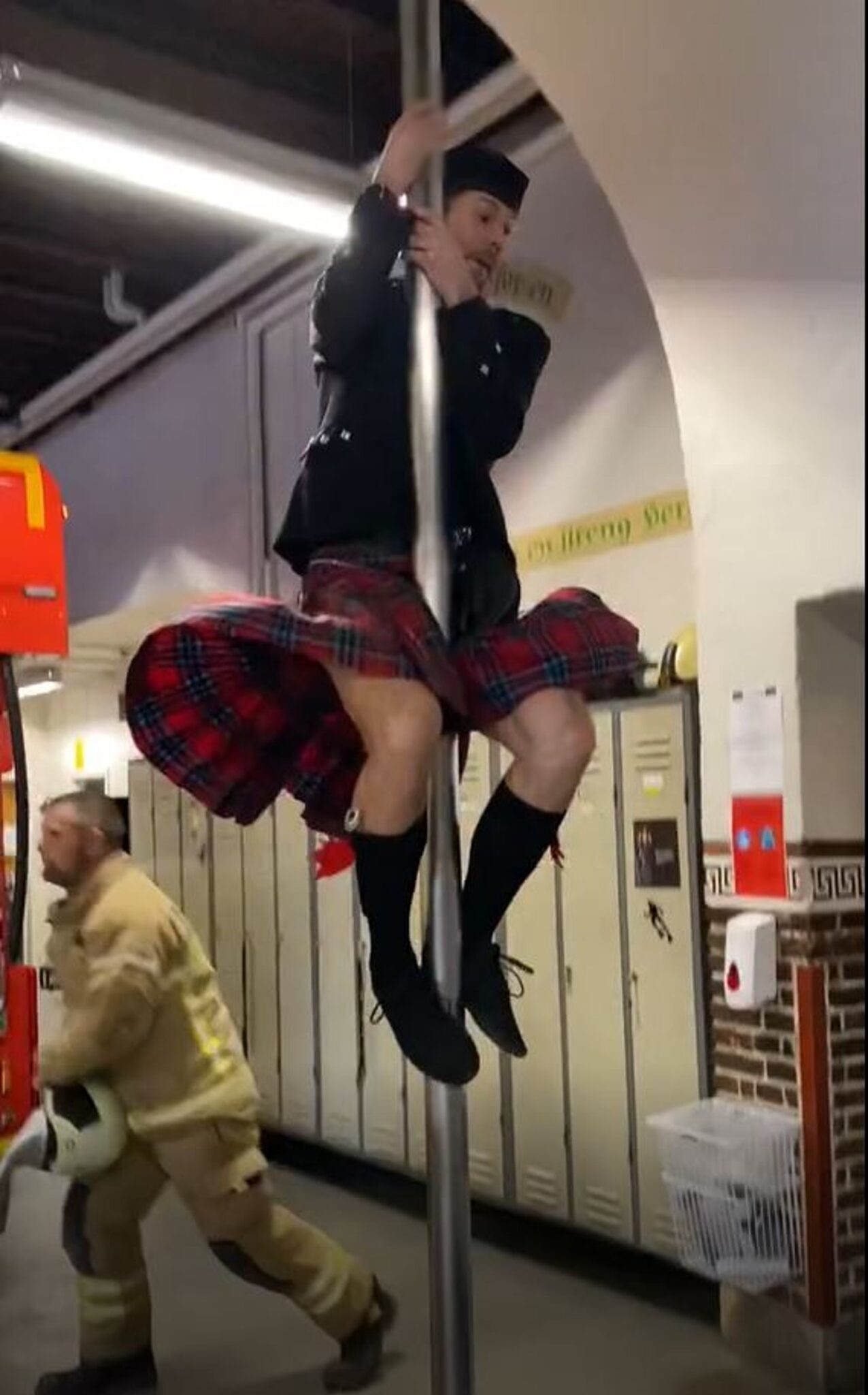 Hilarious comedian sliding down fireman's pole with bagpipes