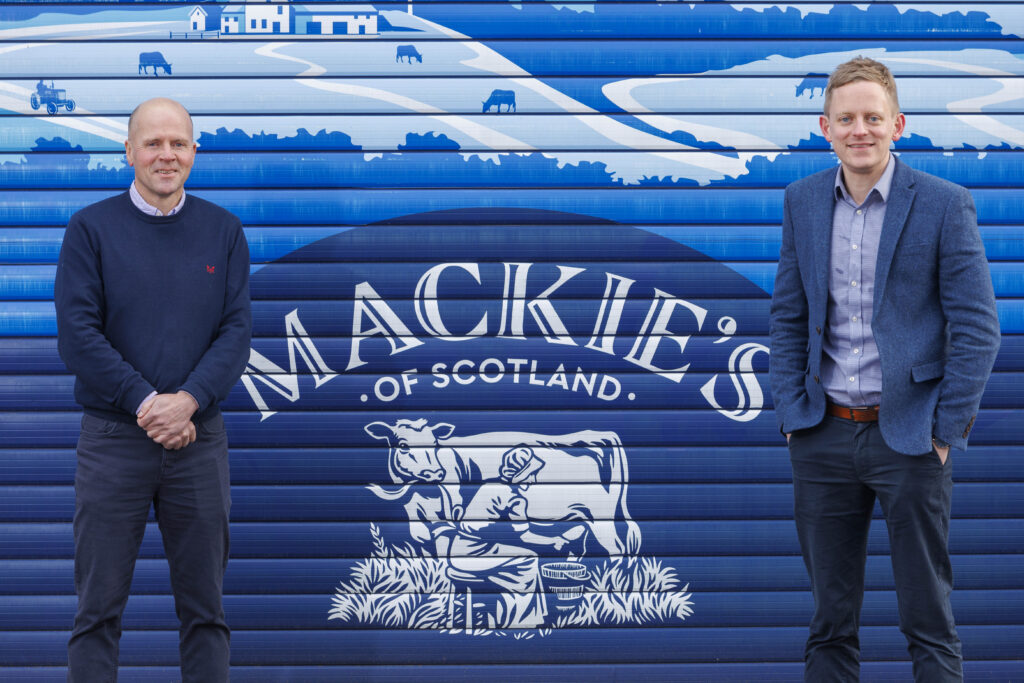 Mac Mackie and Stuart Common stood next to Mackie's logo