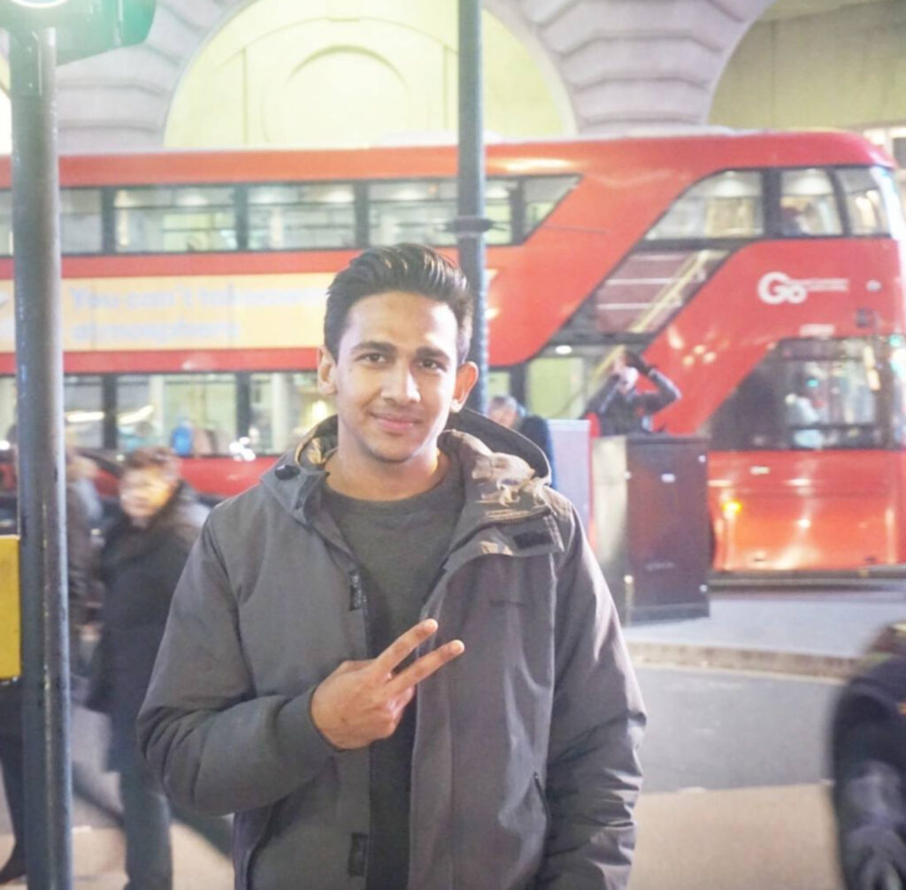Akram Arshad posing in-front of London Bus