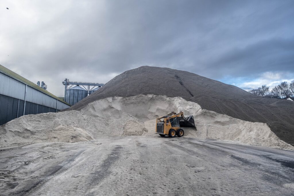 Digger taking a scoop out of an enormous pile of road salt at the Port of Dundee's road salt hub.