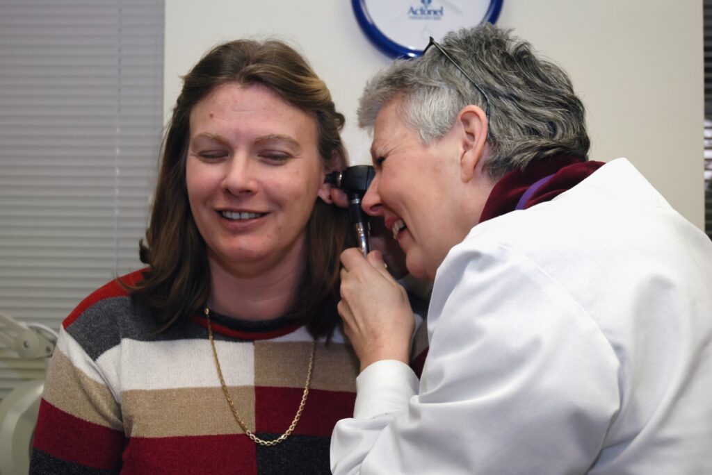 Doctor inspecting woman's ear.