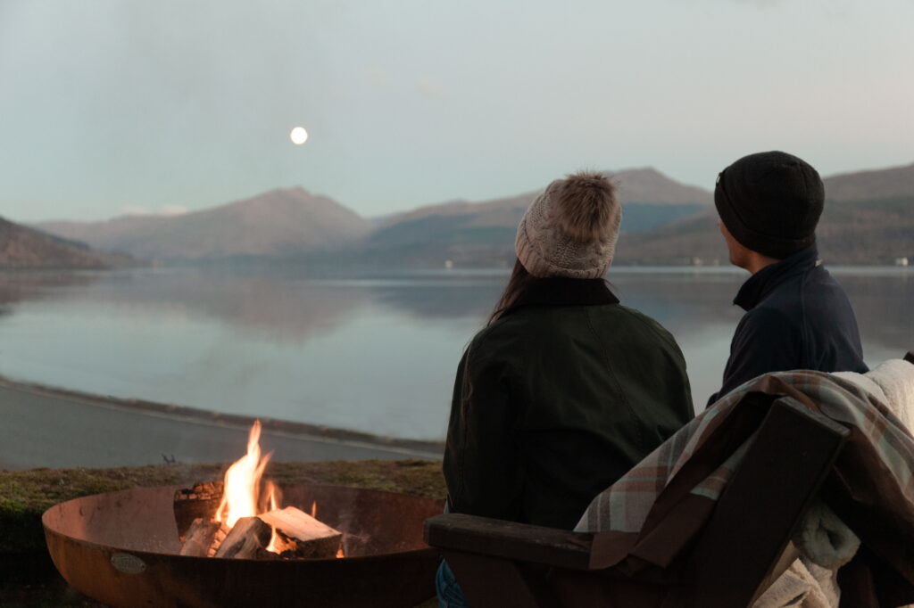 Two people looking across a Scottish lake