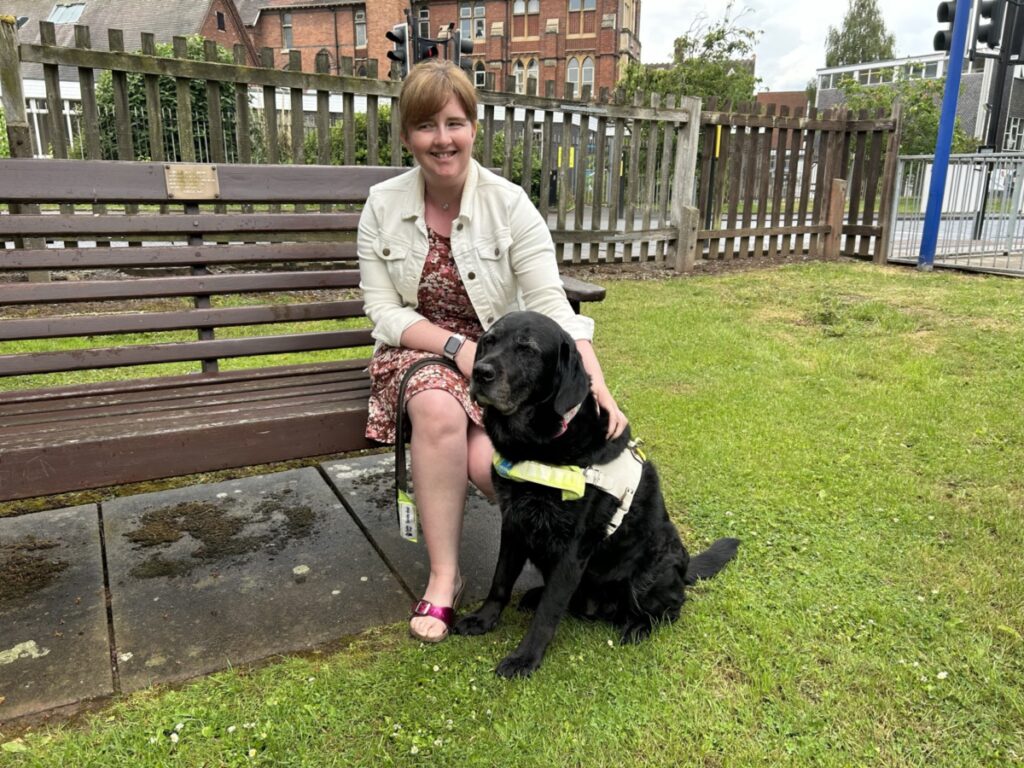 Leanne Moore and her black dog Wanda sat on a bench.