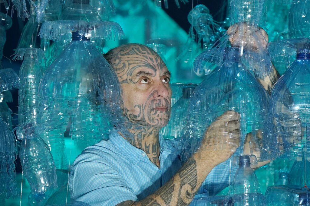 Artist George Nuku puts the finishing touches to the installation of the artwork Bottled Ocean 2123.