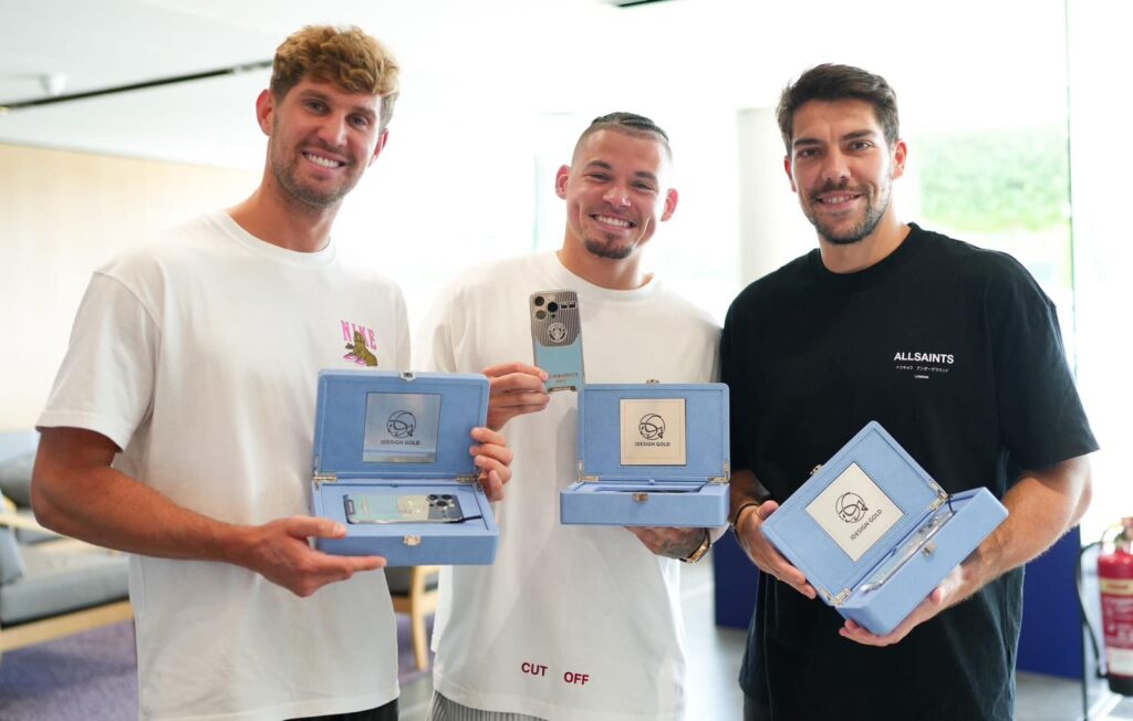 Manchester City players pose with their custom-made smartphones.