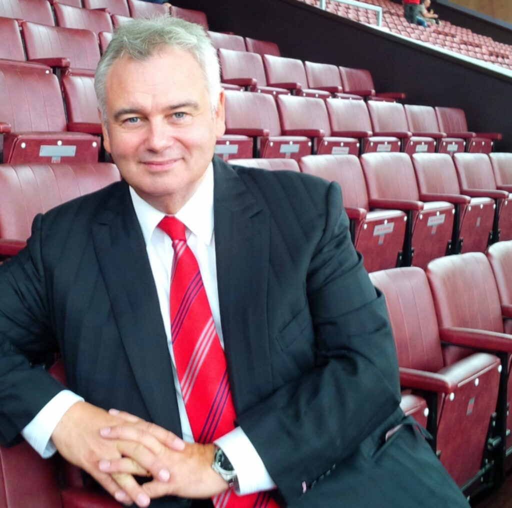 Eamonn Holmes pictured sat at Old Trafford