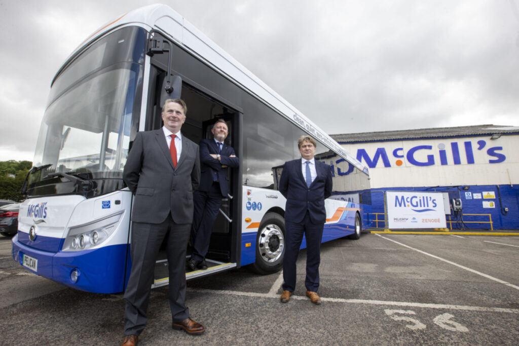 Sandy Easdale, Ralph Roberts, and James Easdale standing next to bus