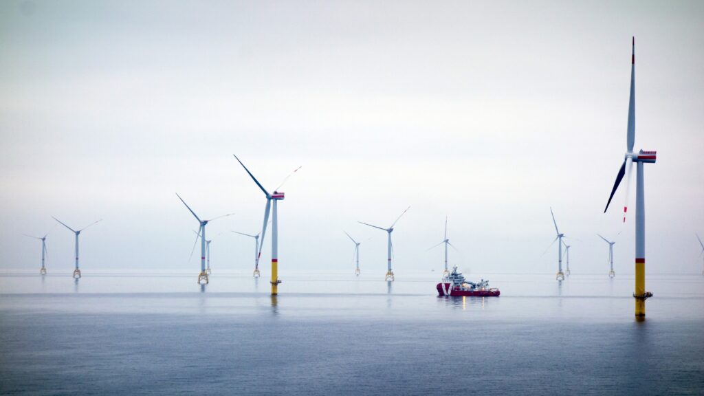 Wind turbines at sea represent the remote conditions faced by maritime vessels and offshore energy operations.